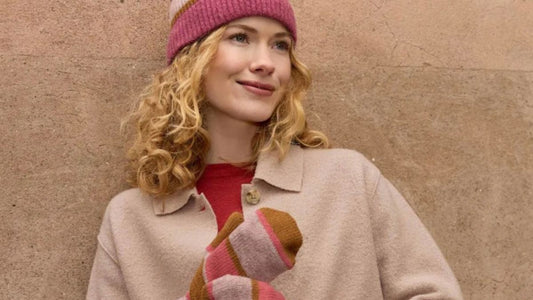 Kvinna med höstig beige ulljacka och härliga rosa stickade vantar